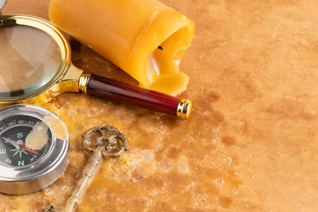 Old compass, magnifying glass and old key on a paper backgroundの写真素材