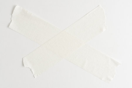 White masking tape in  form of  cross on  white background with   place for copying text.の写真素材