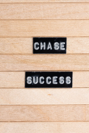 Close up word chase  success written on wooden background.の写真素材
