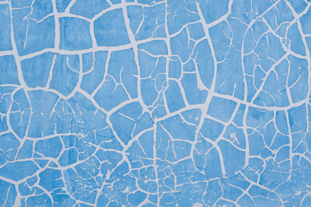 Cracked blue paint on wall. Abstract background and texture for design.