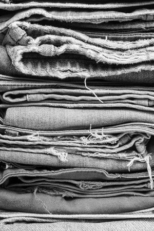 Stack of folded jeans for background. Black and white. Close up.の写真素材