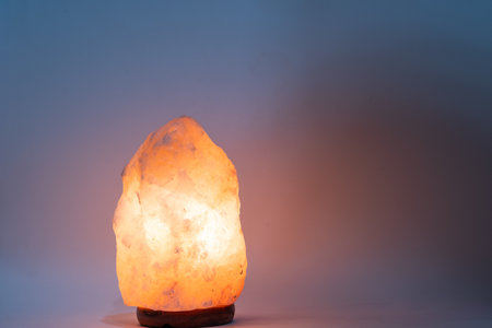 Himalayan salt lamp on blue background.の写真素材