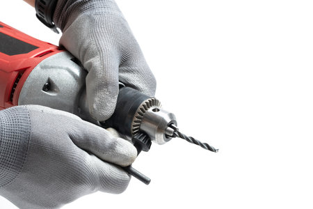 Closeup  an electric drill in  hands worker in gray gloves on white background.