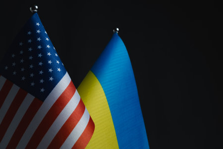 USA and Ukraine flags on dark background.