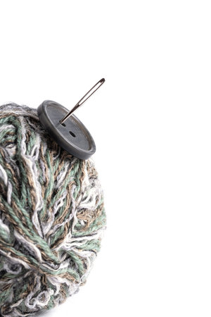 Ball of wool, button and needle on white background, isolate. Hobbies are knitting and needlework.