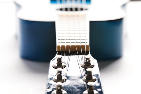 Blue acoustic guitar is illuminated by white daylight, close up.