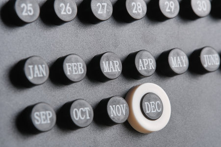Month december on stylish black calendar, close up.
