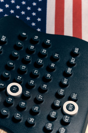 Black desktop calendar with date November 11th on blue background.の写真素材