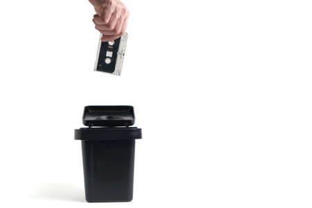Hand disposing of an old audio cassette tape, symbolizing the end of the analog eraの写真素材