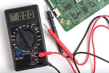 Digital multimeter and microcircuit isolated on a white background.