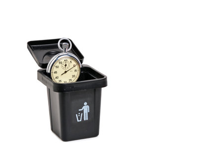 vintage pocket watch in a black trash can isolated on white background
