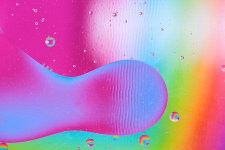 Abstract fluid shape on vibrant colorful background, macro photography of oil in water