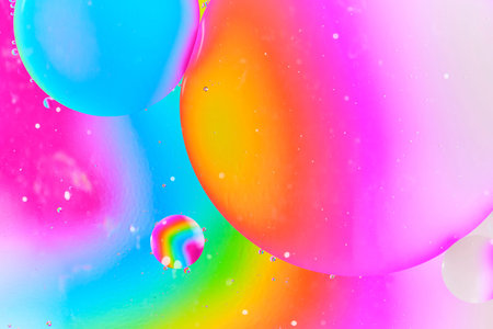 Abstract liquid art showing large overlapping oil bubbles with focus on warm orange and pink glow...