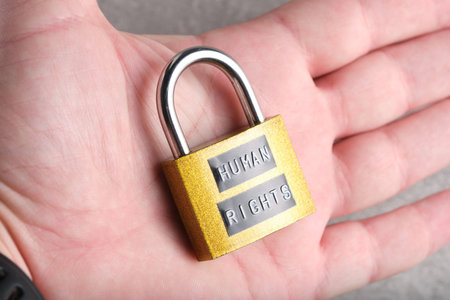 HUMAN RIGHTS, lock held in hand, side view. Emphasizes the concept that human rights are personal...