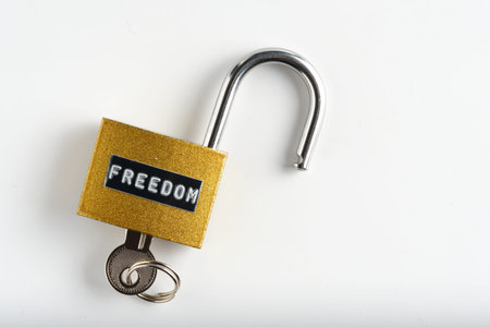 Open golden lock with keys on a clean white background, symbolic of access and independence