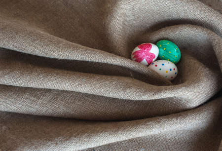 painted Easter eggs lie on sackingの写真素材