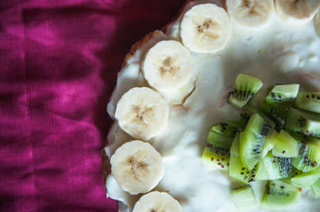 Dessert cheesecake decorated slices of kiwi and banana view from aboveの写真素材