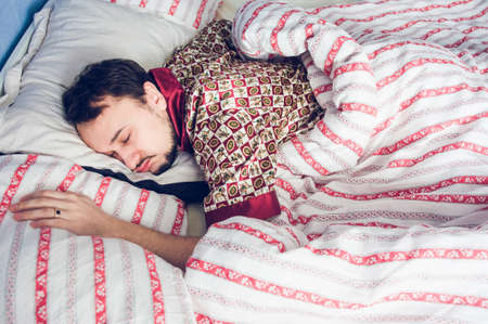 man in silk pajamas sleeping sweetlyの写真素材