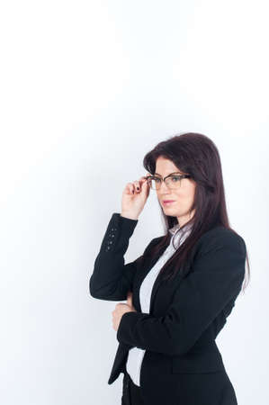 A young dark-haired woman in glasses looking into the distance holding glasses handの写真素材