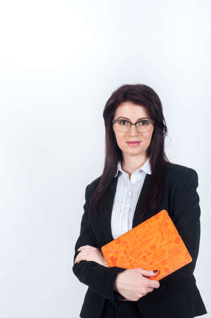 Woman in suit holding tablet in bright orange coverの写真素材