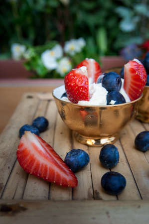 a Delicious ice cream with strawberry pieces and blueberriesの写真素材