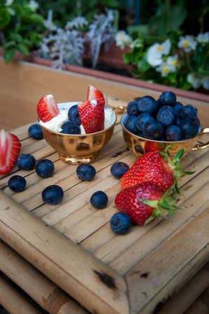 a Delicious ice cream with strawberry pieces and blueberriesの写真素材