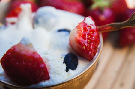 a Delicious ice cream with strawberry pieces and blueberriesの写真素材