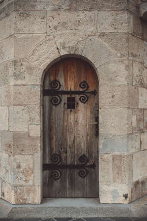 Old narrow door in a stone castle wallの写真素材