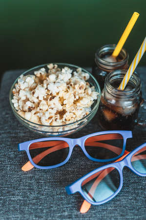 Cola with ice, popcorn in a clear bowl and 3D glassesの写真素材