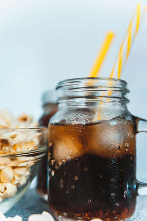 misted bottles of Cola with ice and fresh kettle cornの写真素材