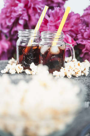 misted bottles of Cola with ice and fresh kettle cornの写真素材