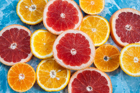 grapefruit, orange and tangerine on blue background. Citrus textureの写真素材