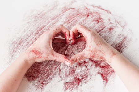 Female hands in red sequins make the figure heart. A Valentines day present with your own handsの写真素材