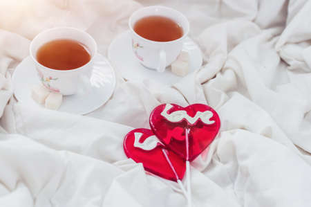 Breakfast in bed in Valentines day. Cup of tea and sweet candies. Love or holiday concept.の写真素材
