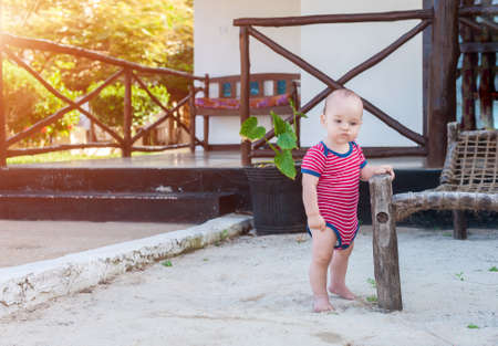 The sad little guy thought. Little boy standing on the white sand.の写真素材