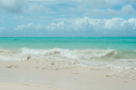 Small waves from a storm in the Indian ocean. Clean water runs on the light sand of the beach.の写真素材