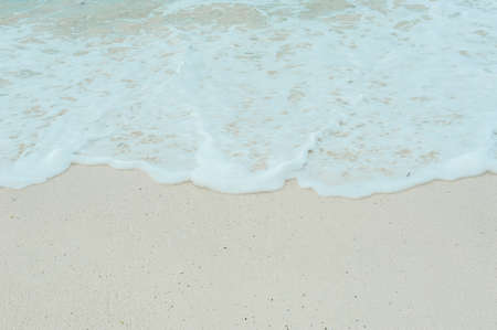 Turquoise waves of the Indian ocean run on the white beach of the island of Zanzibar.