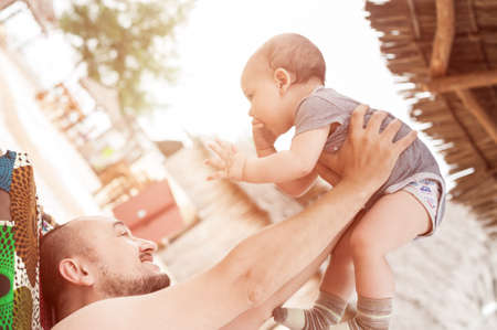 Father and son spend time together. Parent-child relationship. Dad and kid play and hug. Happy family in the sun.の写真素材