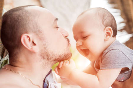 Father and son spend time together. Parent-child relationship. Dad and kid play and hug. Happy family in the sun.の写真素材