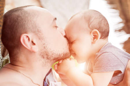 Father and son spend time together. Parent-child relationship. Dad and kid play and hug. Happy family in the sun.の写真素材