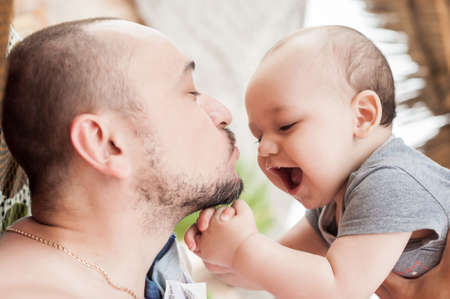 Father and son spend time together. Parent-child relationship. Dad and kid play and hug. Happy family in the sun.の写真素材