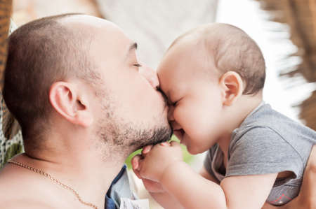 Father and son spend time together. Parent-child relationship. Dad and kid play and hug. Happy family in the sun.の写真素材