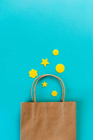 Kraft bag on turquoise background. Eco packaging for shopping. Season of sales and discountsの写真素材