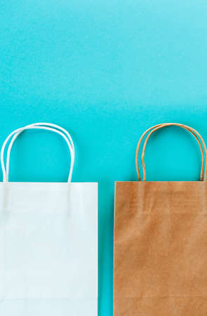 Two Kraft bags on turquoise background. Eco packaging for shopping. Season of sales and discountsの写真素材