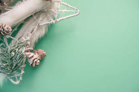 Christmas decoration with white fur, beads and cones on a beautiful mint backgroundの写真素材