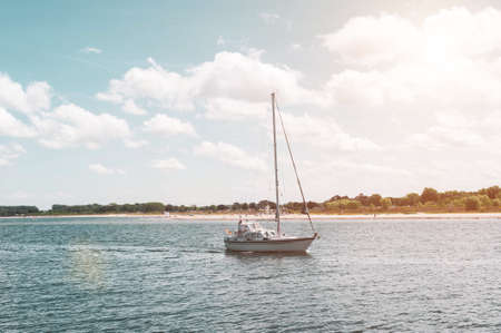 A small sailing yacht is on the waves. Walk by the sea on a Sunny summer day. Sailing regatta.の写真素材