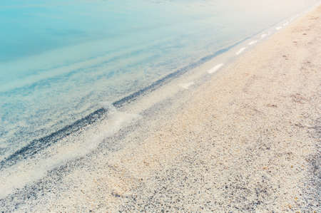 Blue wave with foam on the light sand with black splashes. Backgroundの写真素材