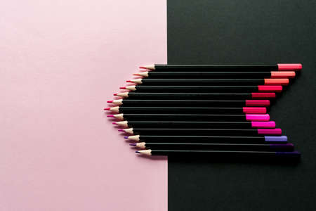 Colored pencils on a pink and black background. Pencil color gradient, top viewの写真素材