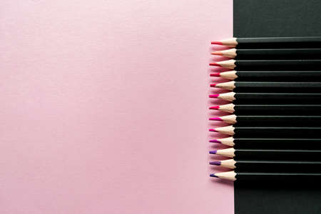 Colored pencils on a pink and black background. Pencil color gradient, top viewの写真素材