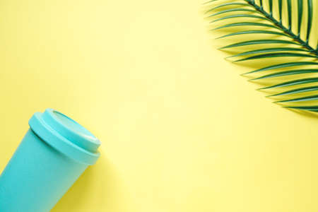Coffee and tea glass mint color on a yellow background. Top view of the plant and Cup. The concept of a drink to go and safe consumptionの写真素材
